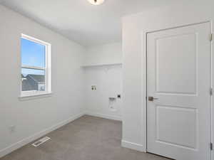 Washroom with hookup for a washing machine, electric dryer hookup, and light colored carpet
