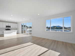 Unfurnished living room with light wood finished floors and recessed lighting