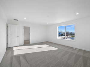 Carpeted empty room featuring recessed lighting