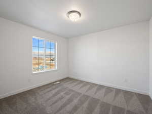 Carpeted spare room with baseboards