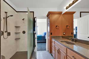 Primary bathroom with vanity and a shower stall with 2 shower heads
