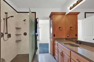 Primary bathroom with vanity and a shower stall with 2 shower heads
