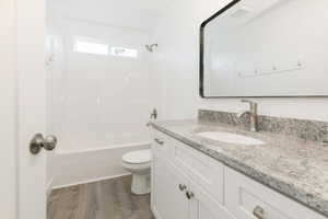 Bathroom with vanity, bathtub / shower combination, and dark wood finished floors
