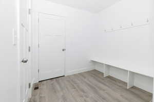 Mudroom with light wood finished floors and baseboards