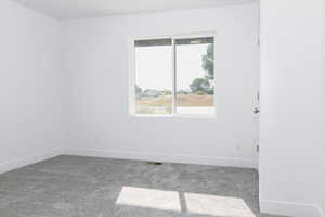 Carpeted empty room with baseboards