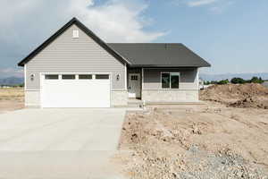 View of front of property with stone siding, a porch, concrete driveway, and an attached garage