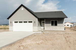 View of front of house with stone siding, driveway, a garage, and a shingled roof