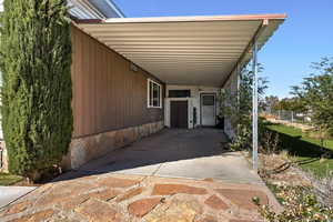 Doorway to property featuring a carport and a patio