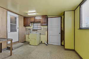Kitchen featuring light floors, dark brown cabinets, and light countertops