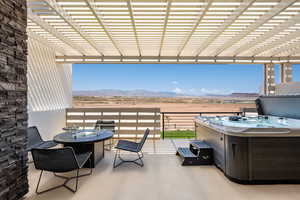 View of patio with a mountain view, a hot tub, view of desert landscape, and a pergola