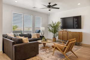 Living room with recessed lighting, light wood-style floors, and a ceiling fan