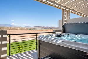 Balcony with a hot tub, a pergola, a mountain view, and a sunroom
