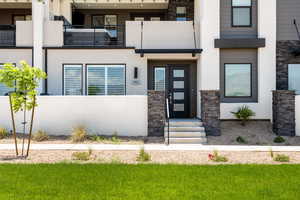 Entrance to property with stone siding and stucco siding
