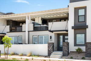 View of front of house featuring stucco siding and stone siding