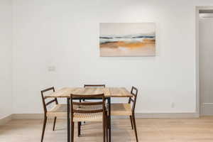 Dining space featuring light wood-style floors and baseboards
