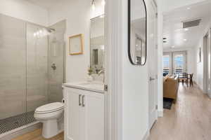 Ensuite bathroom with a stall shower, vanity, and light wood finished floors