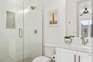 Bathroom with vanity, a shower stall, and ceiling fan