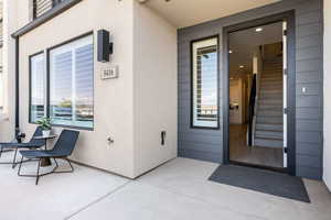 View of exterior entry featuring a patio area and stucco siding