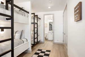Bedroom featuring light wood-type flooring and ensuite bath