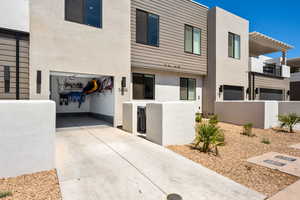 View of front of house featuring stucco siding, driveway, and a pergola