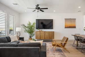 Living area featuring light wood finished floors, recessed lighting, and a ceiling fan