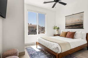 Bedroom with a ceiling fan and light wood-style flooring