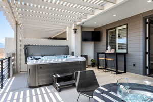 View of patio featuring a hot tub and a pergola