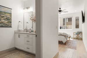 Ensuite bathroom featuring vanity, light wood-style floors, ceiling fan, and recessed lighting