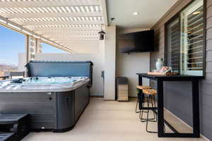 View of patio / terrace featuring a hot tub and a pergola