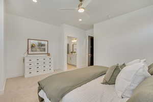 Bedroom featuring light carpet, recessed lighting, ceiling fan, and ensuite bath