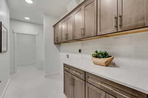 Washroom featuring cabinet space, recessed lighting, hookup for an electric dryer, and hookup for a washing machine
