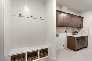 Washroom featuring hookup for a washing machine, electric dryer hookup, and cabinet space