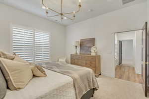 Bedroom featuring light colored carpet, recessed lighting, and a chandelier