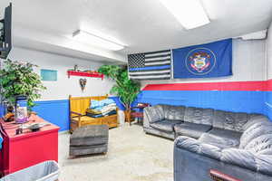 Living room with a textured ceiling and concrete block wall