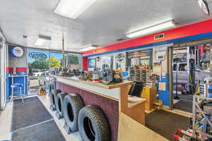Misc room featuring a textured ceiling, a workshop area, and a wall of windows