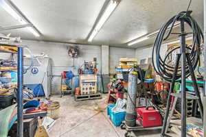 Garage featuring concrete block wall and refrigerator