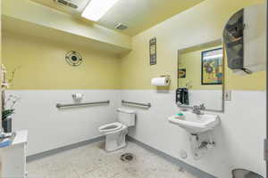 Half bathroom with toilet and light flooring