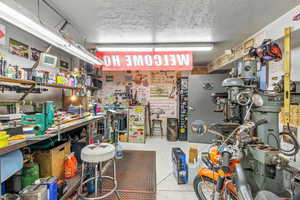 Miscellaneous room featuring a workshop area and a textured ceiling
