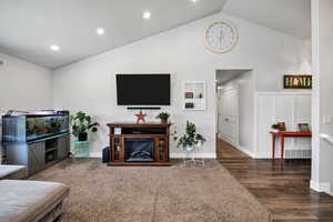 Living room with high vaulted ceiling, dark wood-style flooring, and recessed lighting