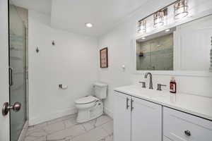 Bathroom with light marble finish flooring, a marble finish shower, vanity, and recessed lighting