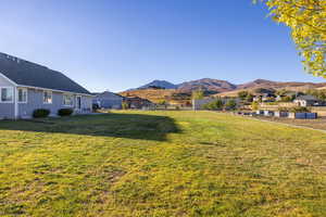 View of yard with lawn and garden area and featuring a mountain view to the south
