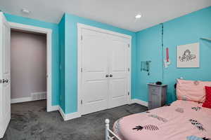 Bedroom featuring dark carpet, a closet, and recessed lighting
