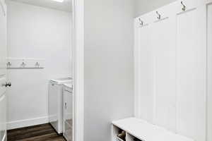 Mudroom with dark wood-type flooring and laundry room with washer and dryer