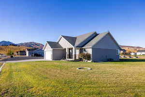 Craftsman inspired home featuring a mountain view to the south, a front lawn, concrete driveway, concrete landscaping curbs,  and an attached garage