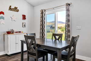 Dining room with dark wood finished floors, sliding glass patio door,  and a mountain view