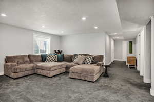 Carpeted living area with a textured ceiling and recessed lighting