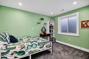 Bedroom with dark colored carpet and recessed lighting
