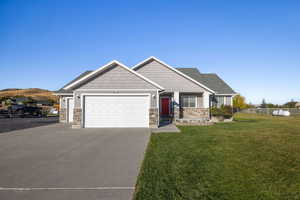 Craftsman house with driveway, stone siding, and a garage