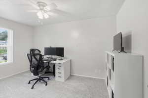 Office space featuring light colored carpet and a ceiling fan