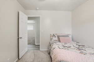 Bedroom with light carpet and baseboards